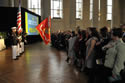 Photo of the 2011 National Crime Victims’ Service Awards recipients (front row) and audience standing as flag bearers from the Military District of Washington Marine Corps Color Guard conduct the Presentation of the Colors ceremony.