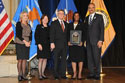 Photo of Michelle D. Scott accepting the Federal Service Award accompanied by Thomas Walker, U.S. Attorney for the Eastern District of North Carolina, with (from left) Joye E. Frost, Acting Director, Office for Victims of Crime; Acting Assistant Attorney General Mary Lou Leary, Office of Justice Programs; and U.S. Attorney General Eric H. Holder, Jr.