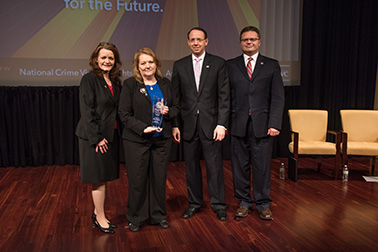 Missey Smith receives the 2019 Ronald Wilson Reagan Public Policy Award with (from left) OVC Director Darlene Hutchinson, Deputy Attorney General Rod J. Rosenstein, and Principal Deputy Assistant Attorney General for the Office of Justice Programs Matt M. Dummermuth.