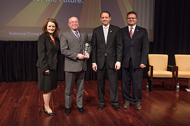 Richard H. Norcross III receives the 2019 Award for Professional Innovation in Victim Services with (from left) OVC Director Darlene Hutchinson, Deputy Attorney General Rod J. Rosenstein, and Principal Deputy Assistant Attorney General for the Office of Justice Programs Matt M. Dummermuth.