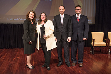 Laura Abbott receives the 2019 Volunteer for Victims Award with (from left) OVC Director Darlene Hutchinson, Principal Deputy Assistant Attorney General for the Office of Justice Programs Matt M. Dummermuth, and Deputy Attorney General Rod J. Rosenstein.