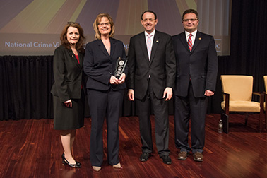 Shari Kastein receives the 2019 Special Courage Award with (from left) OVC Director Darlene Hutchinson, Principal Deputy Assistant Attorney General for the Office of Justice Programs Matt M. Dummermuth, and Deputy Attorney General Rod J. Rosenstein.