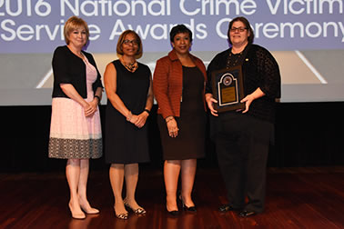 Staff from the Choctaw Nation Victim Services accepts the Award for Professional Innovation in Victim Services. Linda Goodwin Sr., Director Victim Services, accepts the award with (from left) Joye E. Frost, Director, Office for Victims of Crime; Karol V. Mason, Assistant Attorney General; and Attorney General Loretta E. Lynch.