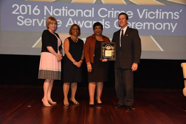 National Crime Victim Service Award recipient Stephen J. Pfleger with (from left) Joye E. Frost, Director, Office for Victims of Crime; Karol V. Mason, Assistant Attorney General; and Attorney General Loretta E. Lynch.