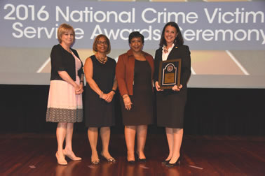 National Crime Victim Service Award recipient Laura Day Rottenborn with (from left) Joye E. Frost, Director, Office for Victims of Crime; Karol V. Mason, Assistant Attorney General; and Attorney General Loretta E. Lynch.