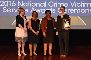 National Crime Victim Service Award recipient Anne P. DePrince, Ph.D. with (from left) Joye E. Frost, Director, Office for Victims of Crime; Karol V. Mason, Assistant Attorney General; and Attorney General Loretta E. Lynch.