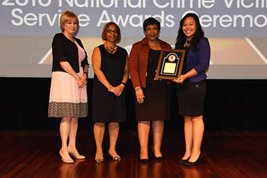 National Crime Victim Service Award recipient Miki Nishizawa with (from left) Joye E. Frost, Director, Office for Victims of Crime; Karol V. Mason, Assistant Attorney General; and Attorney General Loretta E. Lynch.