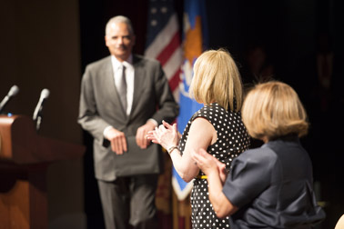 Photo of Attorney General Eric H. Holder, Jr. concluding his speech and receiving a standing ovation from Assistant Attorney General Karol V. Mason and OVC Director Joye E. Frost.