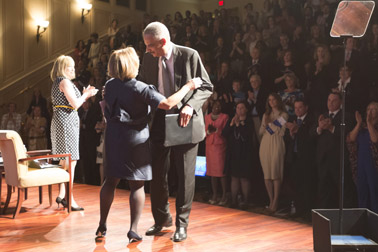 Photo of Attorney General Eric H. Holder, Jr. concluding his speech and receives a hug from Assistant Attorney General Karol V. Mason, which OVC Director Joye E. Frost and attendees at the ceremony give a standing ovation.