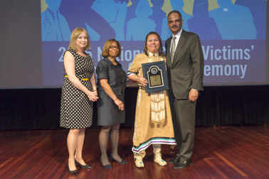 Photo of National Crime Victim Service Award recipient Lisa Heth with (from left) Joye E. Frost, Director, Office for Victims of Crime; Karol V. Mason, Assistant Attorney General, and Attorney General Eric H. Holder, Jr.