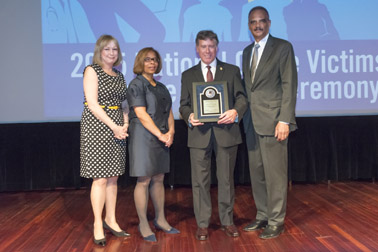 Photo of National Crime Victim Service Award recipient Norman A. Gahn with (from left) Joye E. Frost, Director, Office for Victims of Crime; Karol V. Mason, Assistant Attorney General, and Attorney General Eric H. Holder, Jr.