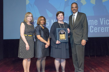 Photo of Rebecca Campbell, Ph.D. receiving the Vision 21 Crime Victim Research Award with (from left) Joye E. Frost, Director, Office for Victims of Crime; Karol V. Mason, Assistant Attorney General, and Attorney General Eric H. Holder, Jr.
