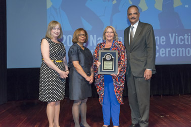 Photo of National Crime Victim Service Award recipient Suzanne Kay Breedlove with (from left) Joye E. Frost, Director, Office for Victims of Crime; Karol V. Mason, Assistant Attorney General, and Attorney General Eric H. Holder, Jr.